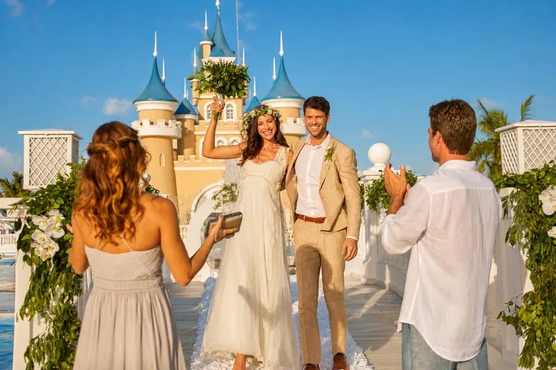 Pareja recién casada celebra la ceremonia ante un castillo en el resort