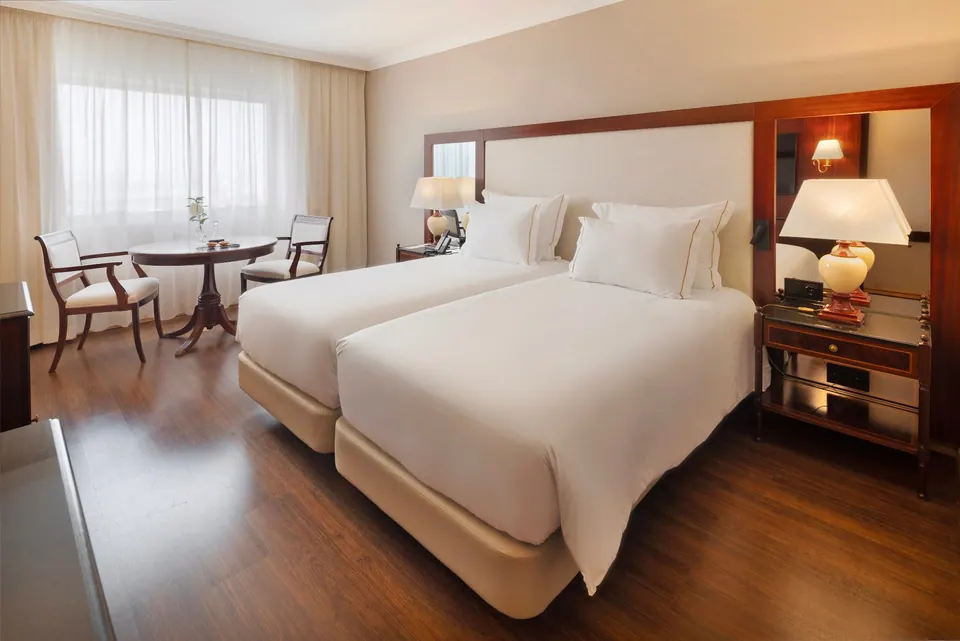 Habitación superior con dos camas y zona de estar en el hotel